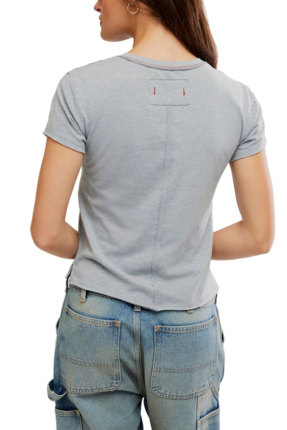 A woman shown from the back wearing a light gray short-sleeve t-shirt and blue jeans against a plain white background.