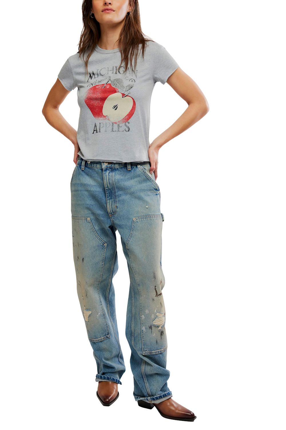 A woman wearing a light gray heathered graphic t-shirt with a distressed red apple print and the words 'MICHIGAN APPLES', paired with blue jeans.