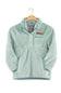 A light mint green textured fleece pullover jacket with a stand collar, buttoned placket, and a brown rectangular logo patch on the chest, hanging on a wooden hanger against a white background.