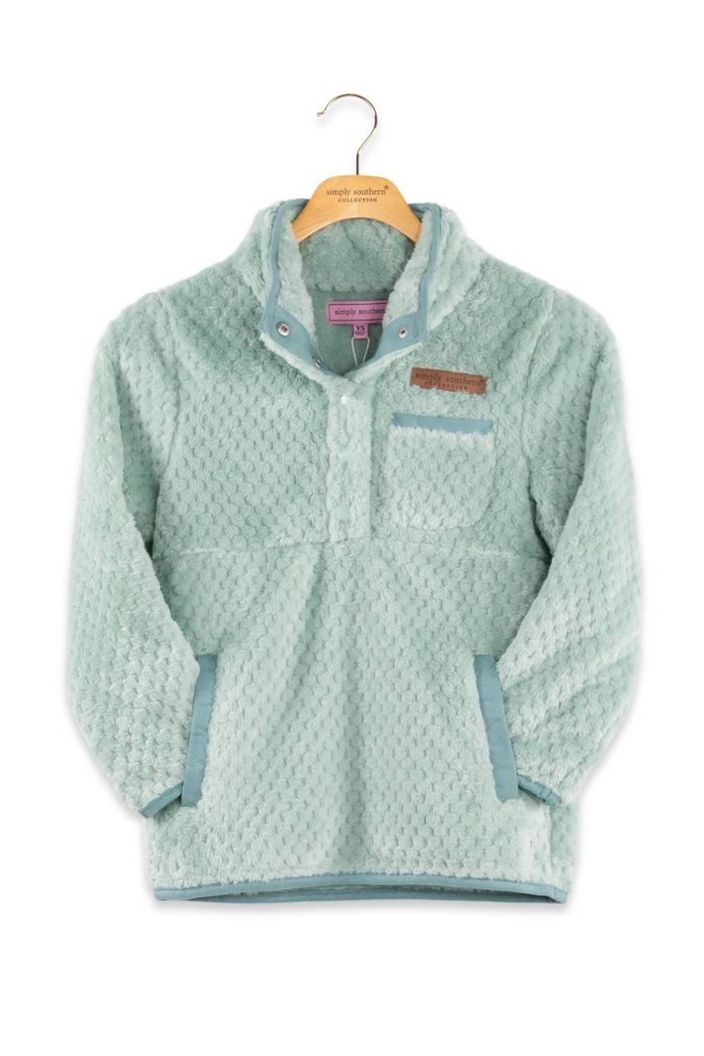 A light mint green textured fleece pullover jacket with a stand collar, buttoned placket, and a brown rectangular logo patch on the chest, hanging on a wooden hanger against a white background.