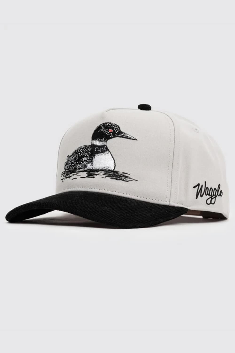 A white structured baseball cap with a black brim, featuring an embroidered loon on the front and the brand name embroidered in black on the side, set against a light gray background.
