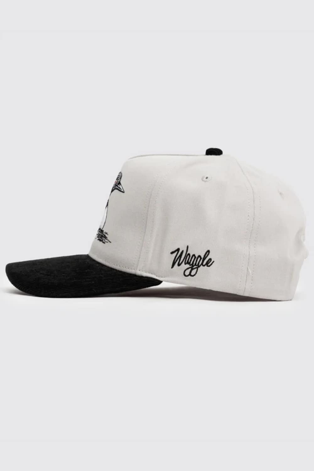 A white structured baseball cap with a black brim, featuring black embroidered graphics and the word 'Waggle' on the side, shown against a light gray background.