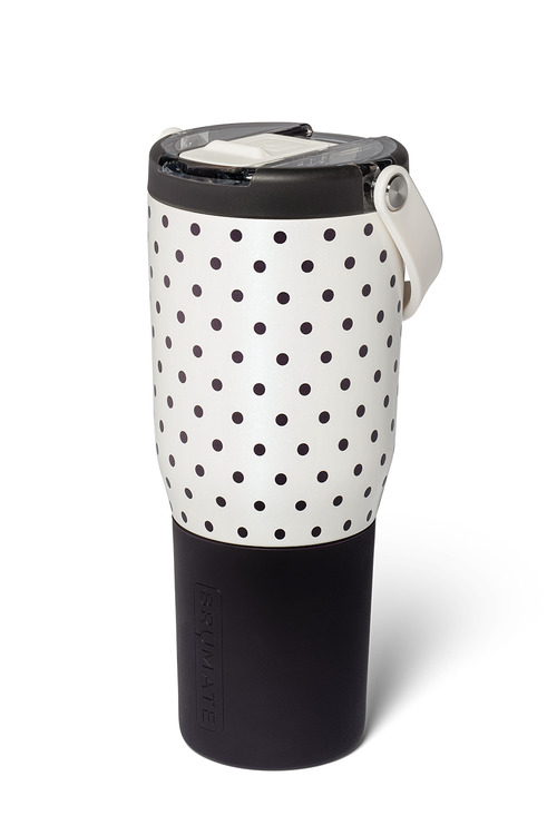 A travel tumbler with a black and white polka dot pattern on the upper half and a solid black lower half, featuring a black lid with a white flip-up straw cover and a white carrying loop.