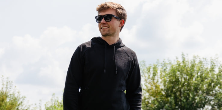 Promotional banner featuring a smiling man wearing black sunglasses and a black hoodie while standing in a sunny outdoor setting
