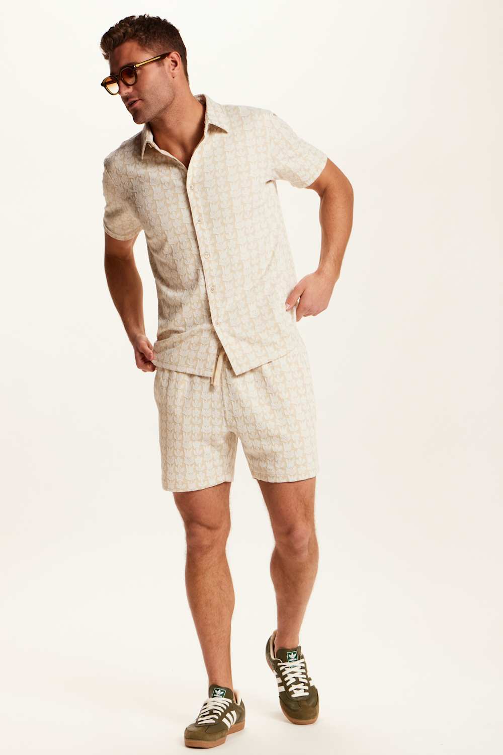 Weatherproof Vintage Knit Jacquard Coatfront Shirt for Men in Cream; Man wearing a beige linen suit with shorts on a white background