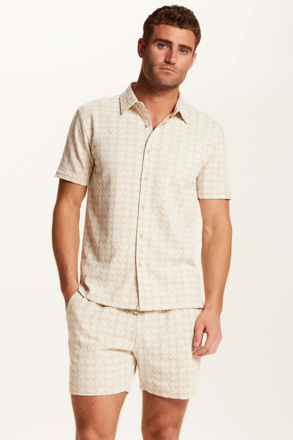 Weatherproof Vintage Knit Jacquard Coatfront Shirt for Men in Cream; Man wearing a matching beige shirt and shorts set on a white background