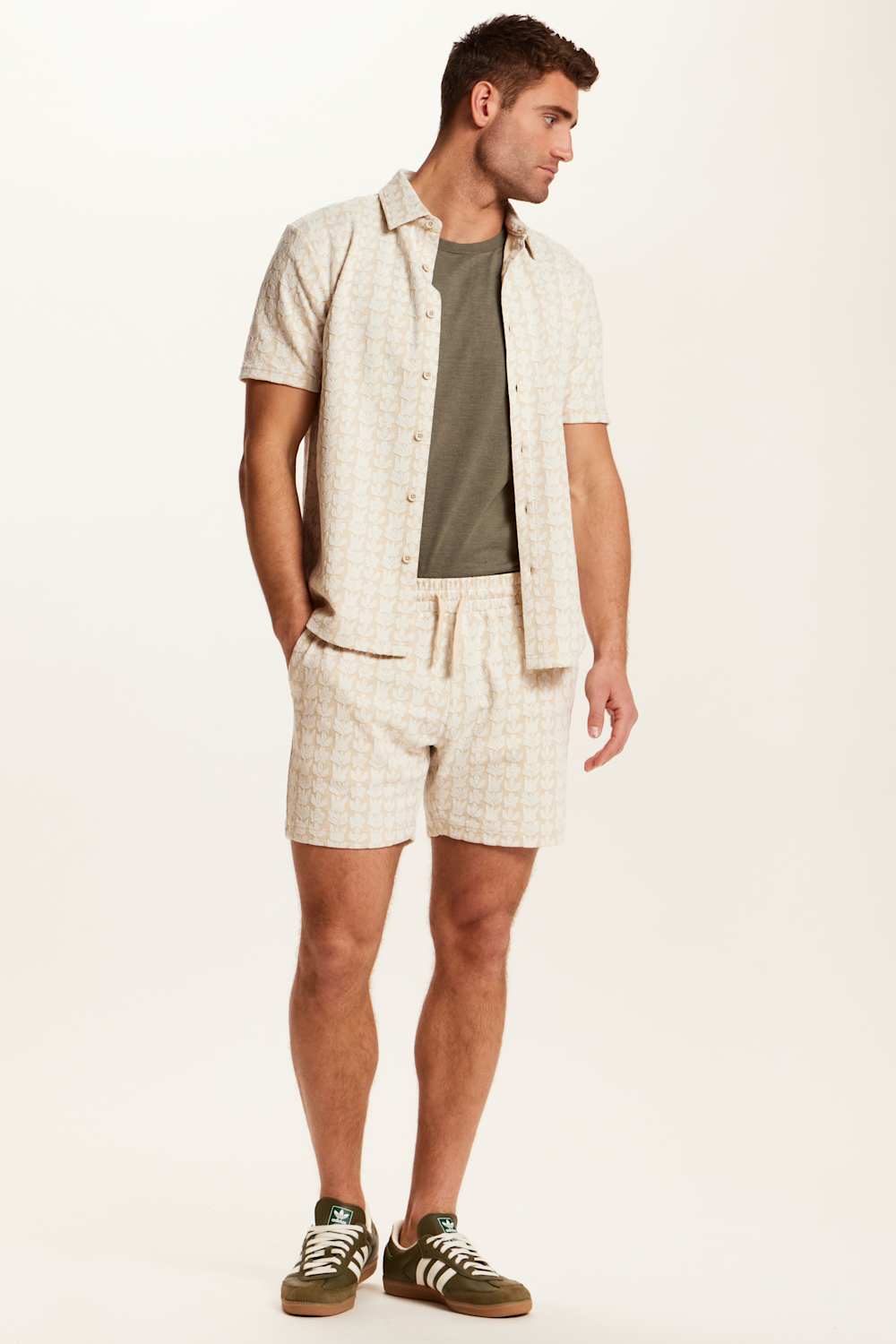 Weatherproof Vintage Knit Jacquard Coatfront Shirt for Men in Cream; Man wearing a beige shirt, green t-shirt, and shorts on a white background