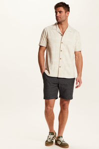 Weatherproof Vintage Bandana Camp Shirt for Men in Tan; Man wearing a beige short-sleeve shirt and dark shorts on a white background
