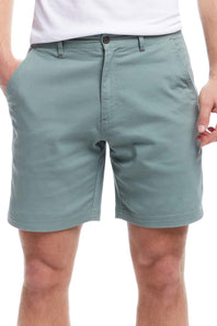 Person wearing light green shorts on a white background
