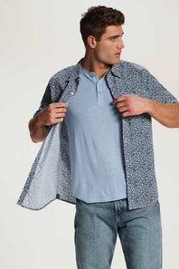 Weatherproof Vintage Poplin Button Up Shirt for Men in Teal; Man wearing a light blue shirt and patterned jacket against a white background