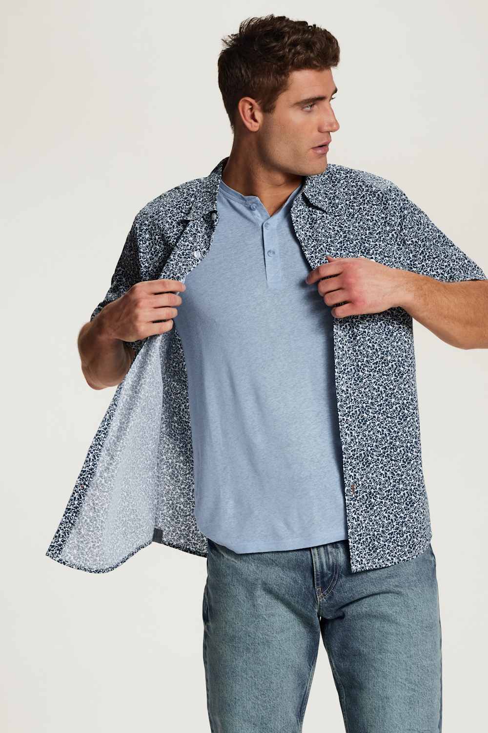 Weatherproof Vintage Poplin Button Up Shirt for Men in Teal; Man wearing a light blue shirt and patterned jacket against a white background