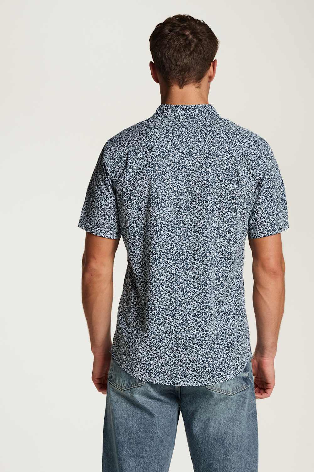 Weatherproof Vintage Poplin Button Up Shirt for Men in Teal; Man wearing a blue patterned shirt and jeans on a white background