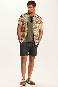 Weatherproof Vintage Camp Collar Printed Shirt for Men in Wheat; Man wearing a floral shirt, gray t-shirt, and shorts on a white background