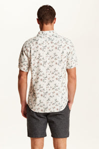 Weatherproof Vintage Linen Rayon Printed Shirt for Men in Cloud Pink; Man wearing a floral short-sleeve shirt and dark shorts on a white background