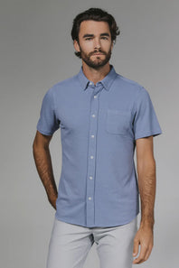 Man wearing a blue checkered shirt against a gray background