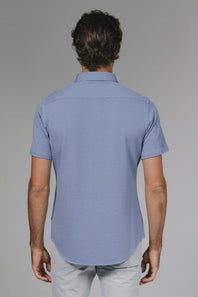 Man wearing a blue checkered shirt against a gray background