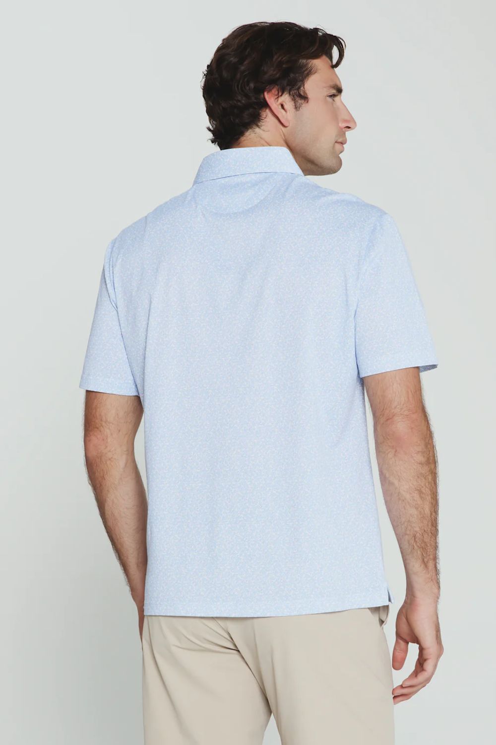 7Diamonds Aires Polo for Men in Light Blue; Man wearing a light blue short-sleeve shirt and beige pants against a plain background