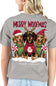 A woman wearing a gray short-sleeve t-shirt, viewed from the back. The shirt features a large graphic print of three dachshunds dressed in Christmas sweaters and Santa hats, with the text 'MERRY WOOFMAS' and 'simply southern' collection' printed below.