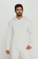 A man wearing a light heather gray hooded sweatshirt and matching sweatpants, standing against a plain light gray studio background.