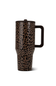 A travel tumbler with a brown and black leopard print pattern, featuring a dark brown handle and lid, shown on a plain white background.