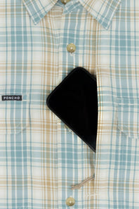 Close-up of a light blue, beige, and white plaid button-down shirt with a black smartphone tucked into the chest pocket. A small black brand tag on the pocket reads PONCHO.