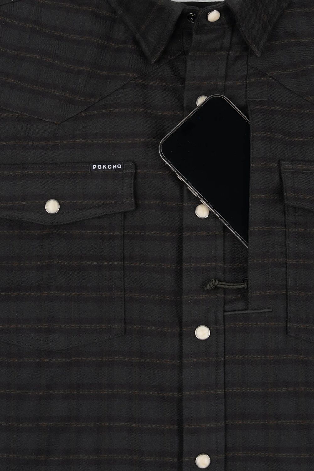 Close-up of a dark charcoal plaid button-up shirt with a smartphone tucked into one of the chest pockets. The brand name 'PONCHO' is printed in white on the left chest pocket.