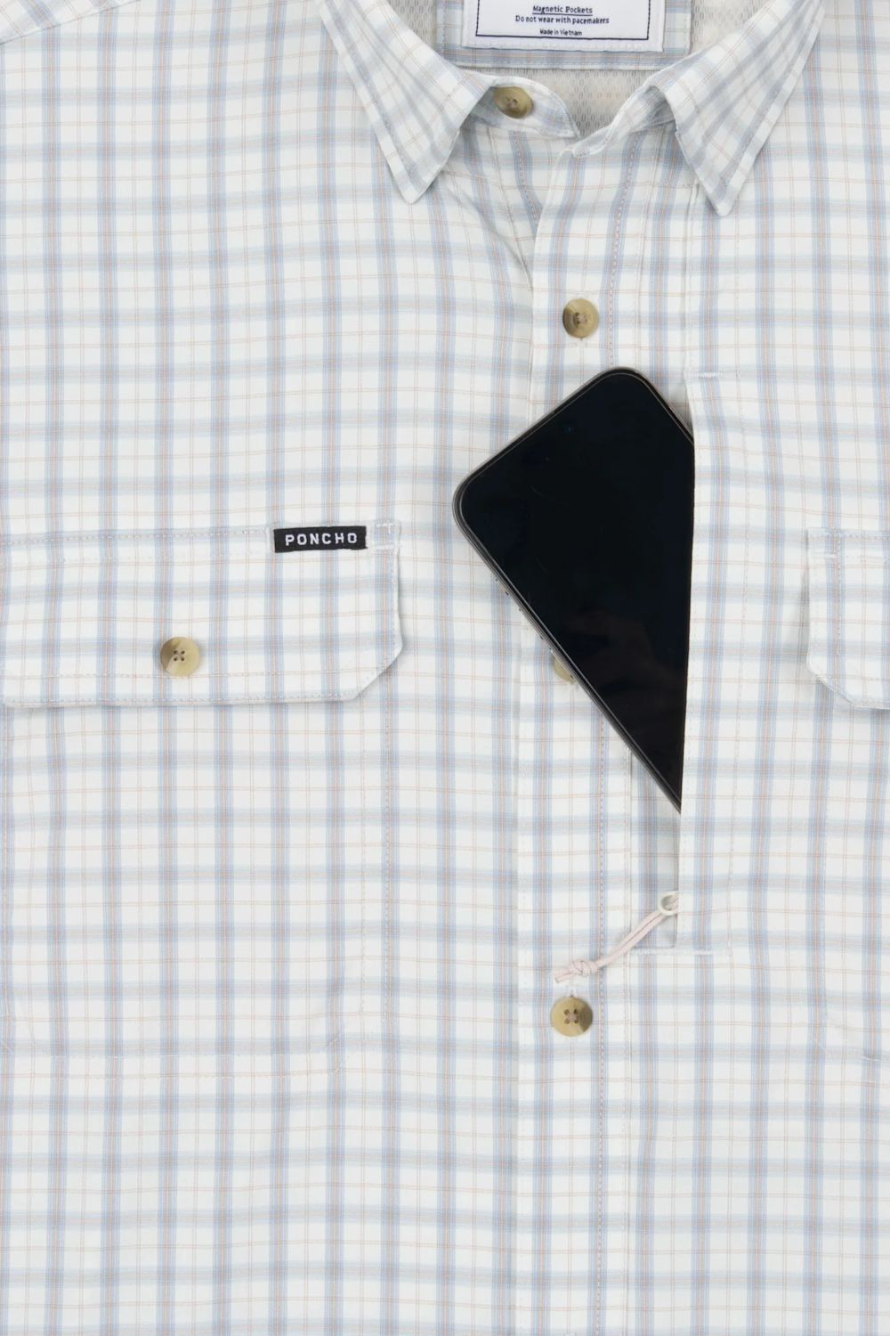 A close-up of a light blue and white checkered button-down shirt with a black smartphone resting in the chest pocket. The brand label 'PONCHO' is visible on the pocket flap.