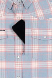A close-up of a light blue and pink plaid button-down shirt with a black smartphone placed on the chest pocket area.