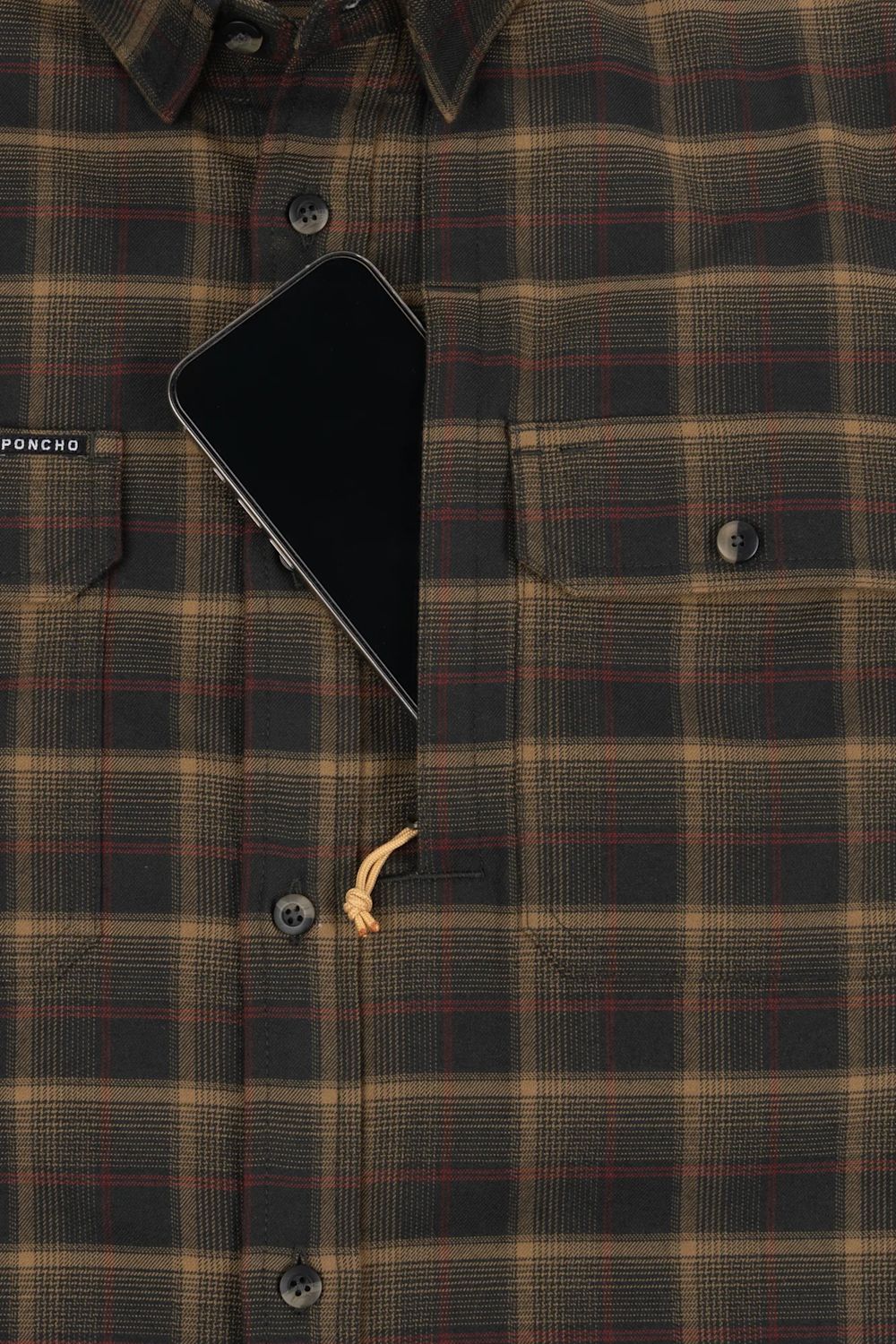 Close-up of a plaid button-up shirt in dark olive green, tan, and red, with a black smartphone tucked into the chest pocket and a small tan drawstring visible.