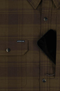 Close-up of a brown plaid button-up shirt with a chest pocket and a small visible PONCHO label, with a black phone partially tucked into the right pocket.