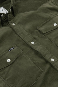 Close-up of an olive green button-up shirt jacket with silver snap buttons, chest flap pockets, and a small black brand tab reading PONDIO.
