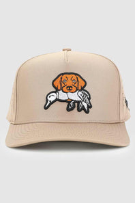 A beige trucker-style cap featuring an embroidered patch of a brown dog holding a white duck on its neck, set against a plain light gray background.