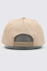 A beige snapback cap viewed from the back, featuring a perforated fabric crown and a matching beige adjustable strap on a dark gray base.