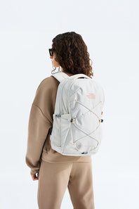 Person wearing a white backpack on a plain background