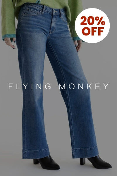 Promotional graphic with a person wearing a pair of flare jeans in front of a basic background with an image overlay darkening the image. The Flying Monkey Jeans logo in white is in the center of the image and a circular callout in the upper right corner that reads 20% OFF