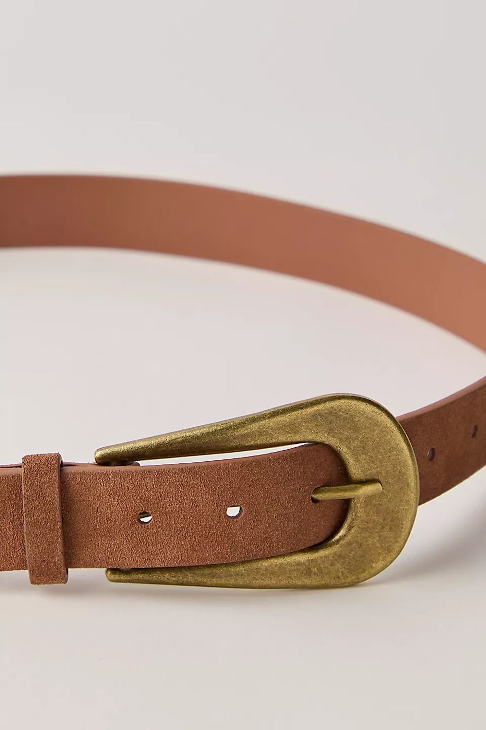Brown leather belt with a gold buckle on a light beige background