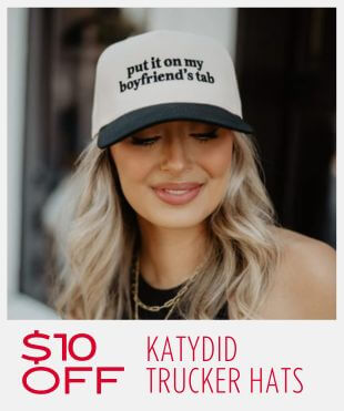 Women wearing a cream and black colored trucker hat with text that reads 