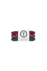 Three beaded stretch hair ties stacked together on a white background, featuring glossy dark teal, translucent pink with silver flecks, and deep burgundy beads.