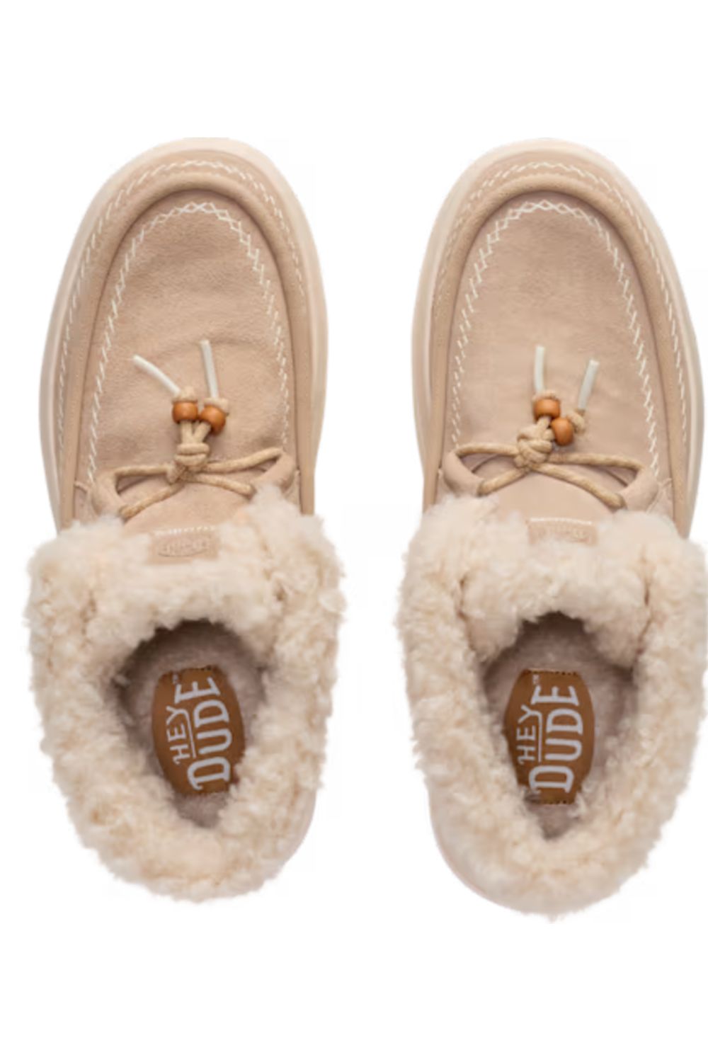 Shoes in beige suede with a thick cream shearling lining and matching beige laces with wooden tips, shown from a top-down view on a white background.