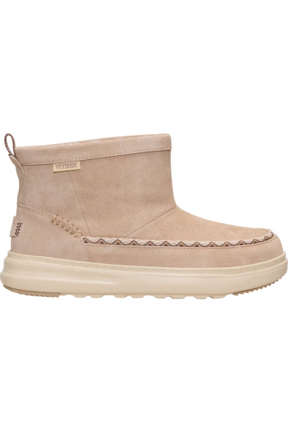 A single ankle suede boot in a light beige or taupe color, featuring a thick cream-colored sole and decorative stitching along the vamp, shown against a plain white background.