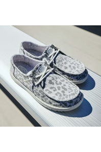 A pair of low-top boat-style shoes with a gray and white leopard print pattern, white laces, and dark blue side panels, displayed on a white textured surface.