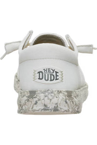White low-top sneaker with a textured, distressed silver sole and a central patch reading 'HEY DUDE'.