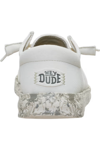 White low-top sneaker with a textured clear sole and a white heel patch featuring the 'HEY DUDE' logo.