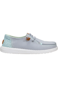 A light blue suede boat shoe with a textured light blue heel panel, white sole, and a small brown leather detail on the side.