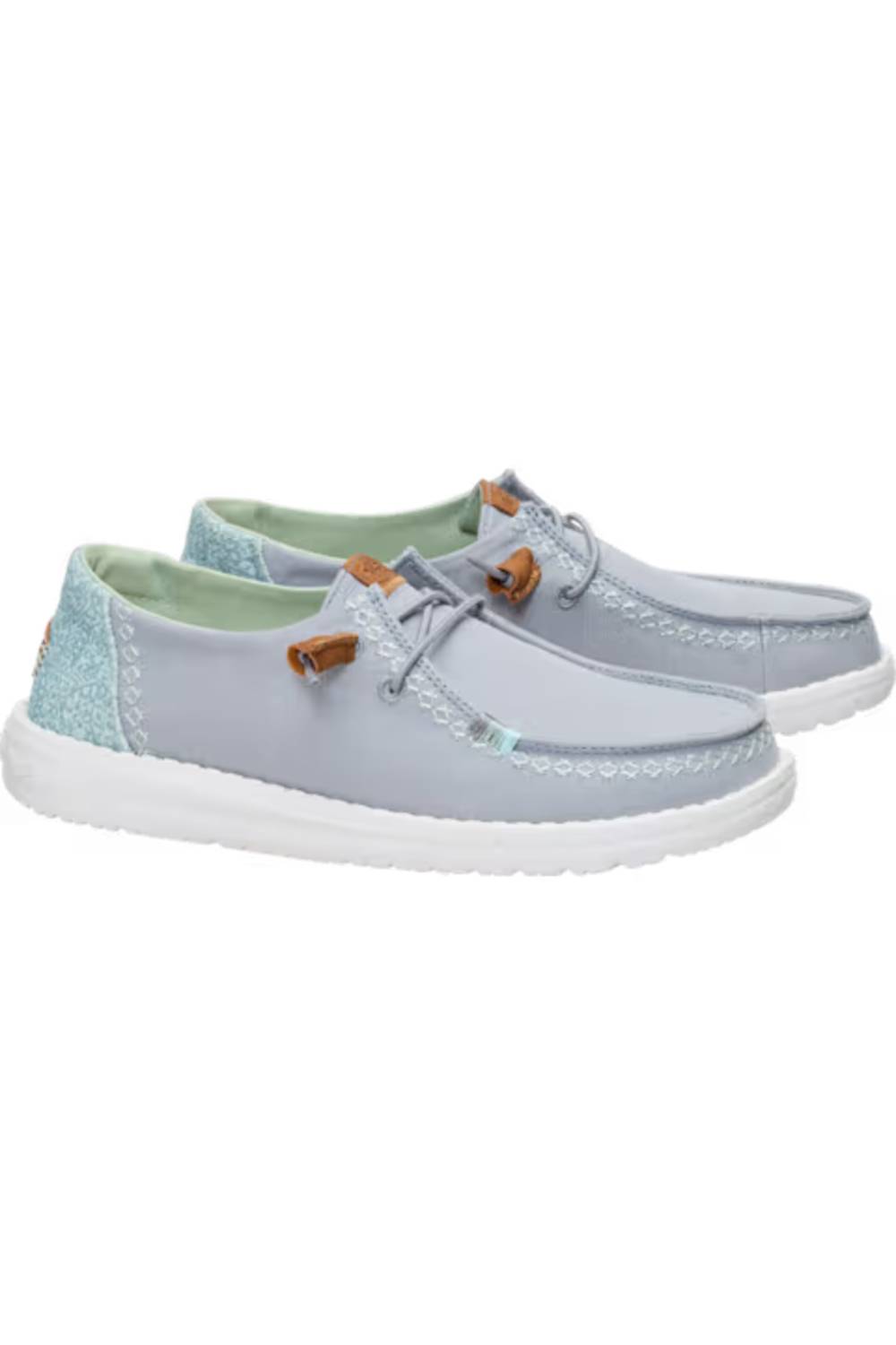 A pair of light blue boat shoes with white soles, featuring light green lining and small brown leather accents on the laces, set against a plain white background.