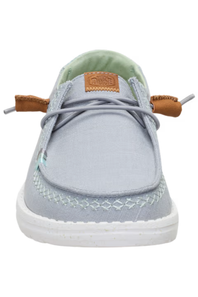 A light gray canvas boat shoe with brown leather laces, a white sole, and a light green interior lining, shown from a front-facing perspective on a white background.