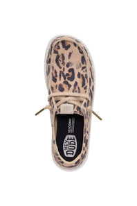 A single platform loafer from Hey Dude, featuring a beige and brown leopard print upper, beige laces, and a black insole with the brand logo.