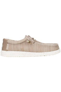A single slip-on shoe with a textured beige woven upper, matching beige laces, and a speckled white sole, shown from a front-facing perspective on a white background.
