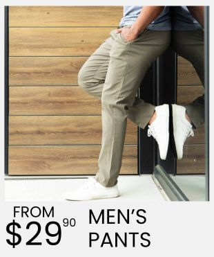 Person leaning up against a black side wall and wood panel wall behind them wearing olive green pants and white sneakers and a promotional banner that says 