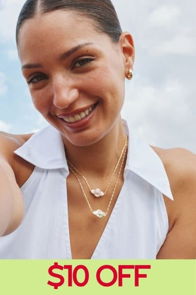 Woman smiling wearing 2 necklaces with a collared shirt and a $10 off callout at the bottom of the image